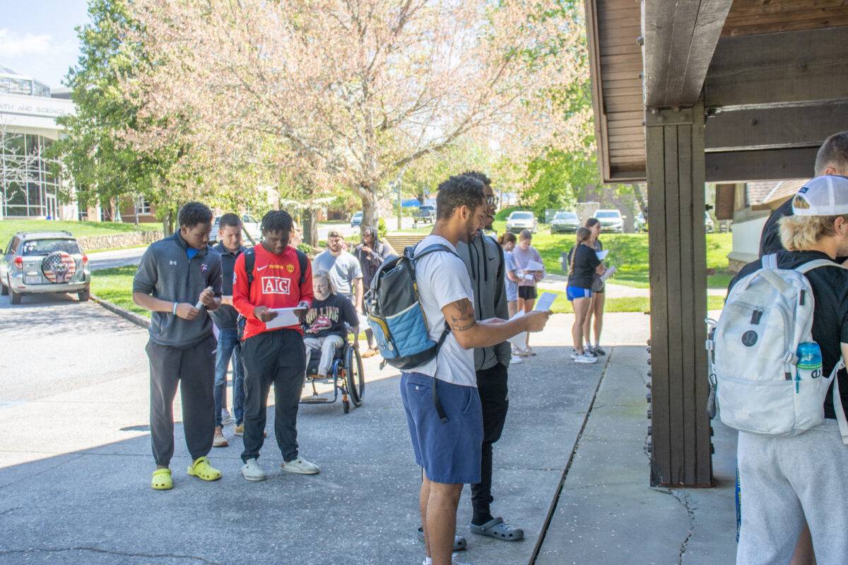 Students line up on the sidewalk to enter the simulation.