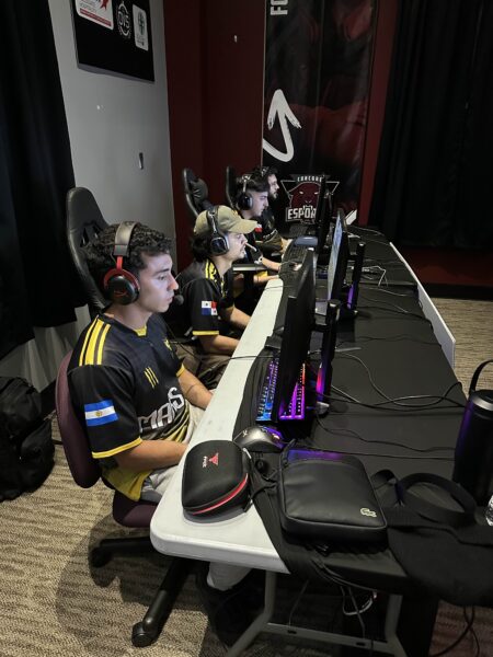 four esports team members sit at gaming computers playing Call of Duty