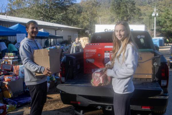 Students load boxes into a pickup truck.