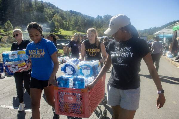 Students transport relief supplies in a shopping cart.