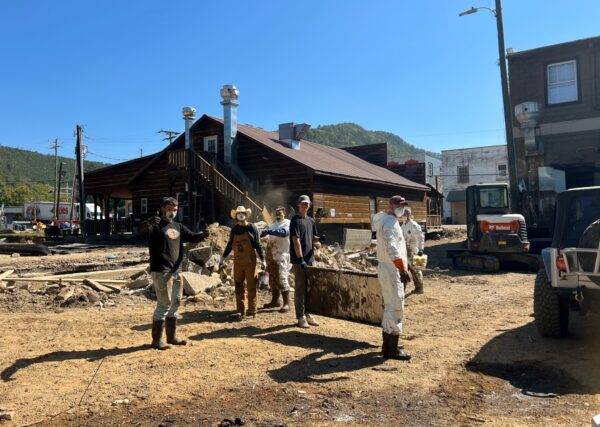 Students work in a mud-covered parking lot.