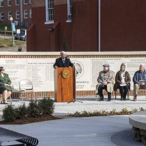 Pres. Floyd speaks behind the lectern in front of the Founders Memorial.