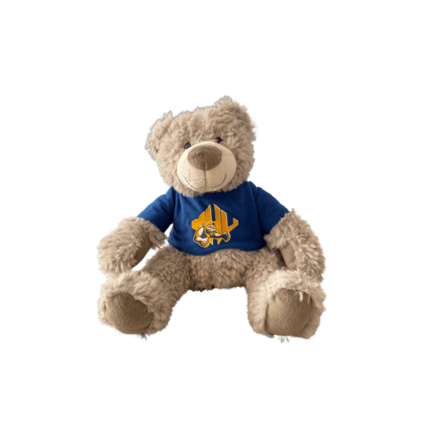 White or light tan fuzzy stuffed bear wearing a blue MHU tshirt with the athletics logo