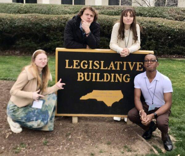 Cassie Berry, TJ Burske, Alexis Allen, and AJ Rivers pose at the Legislative Building sign in Raleigh